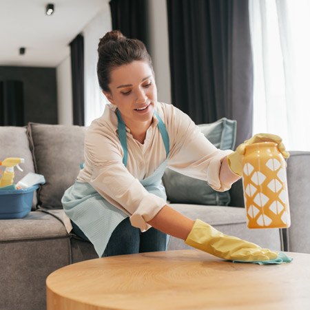 house cleaning professionals cleaning under yellow vase